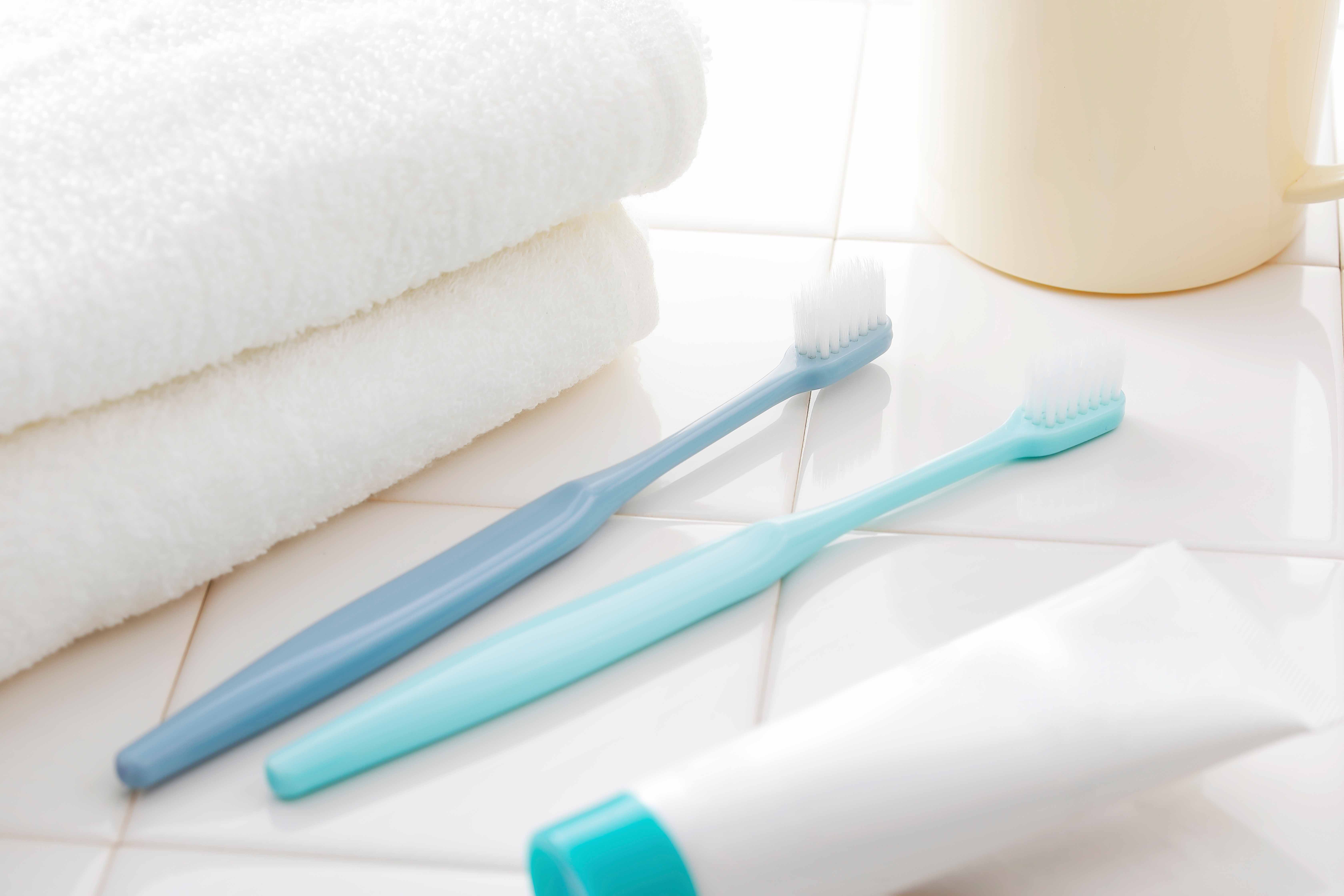 タオルと歯ブラシ2本、歯磨き粉、コップが置かれている