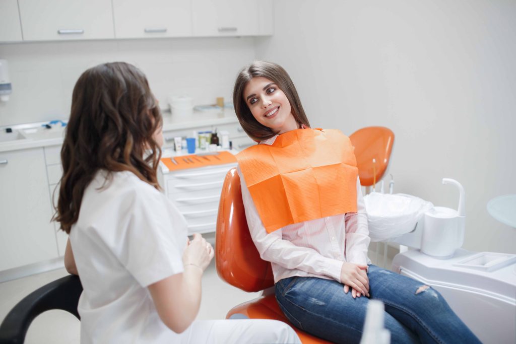 歯科の椅子に座って話を聞く患者