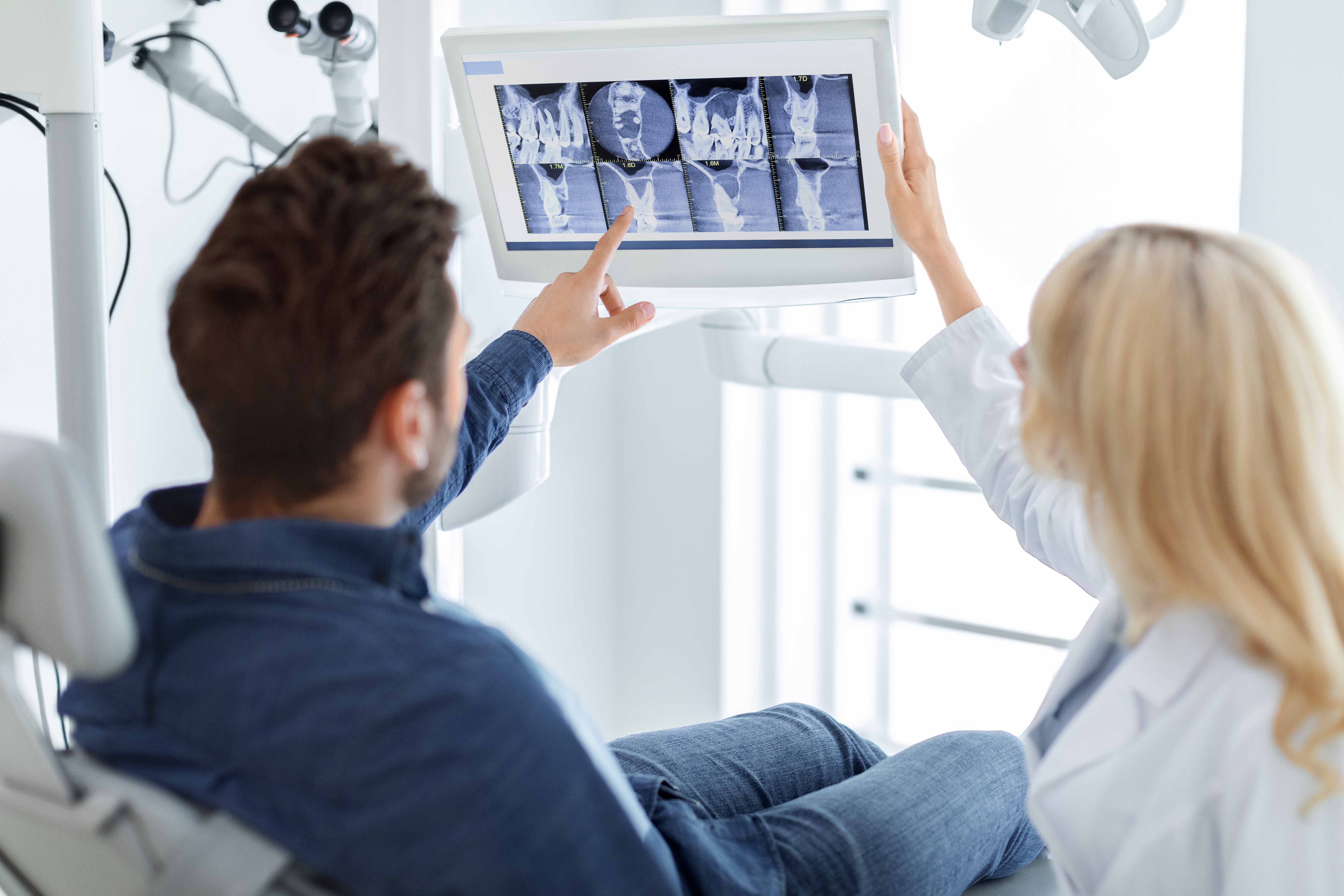 歯のレントゲン写真を見ている男性患者と女性歯科医師