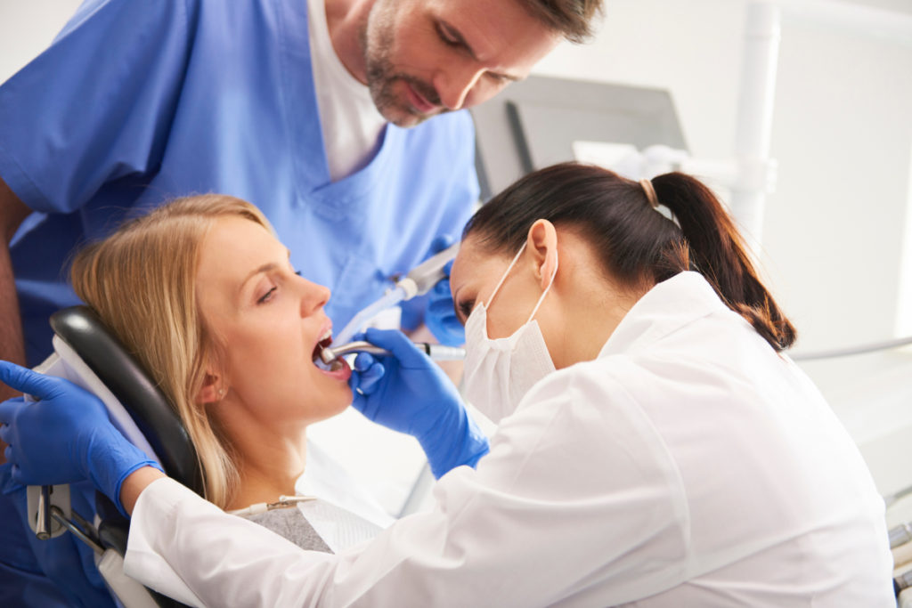 患者と患者の歯を見ている歯科医師