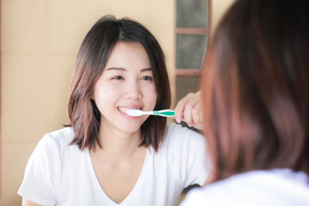 笑顔で歯を磨いている女性