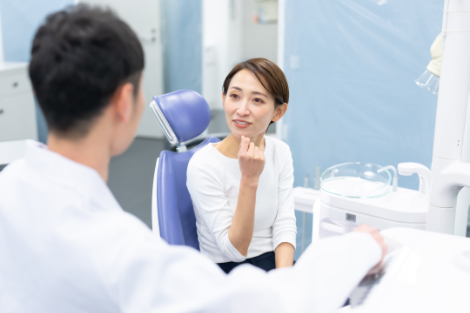 歯科医院で銀歯を白くする相談をする女性
