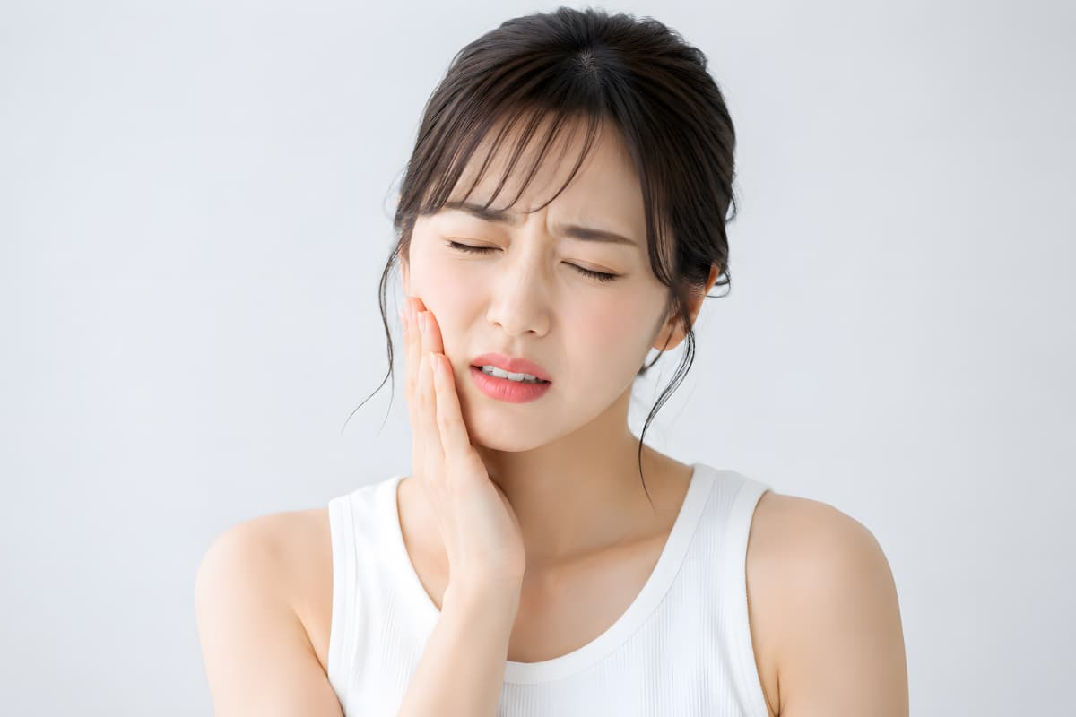 セラミック治療後に歯がしみる女性